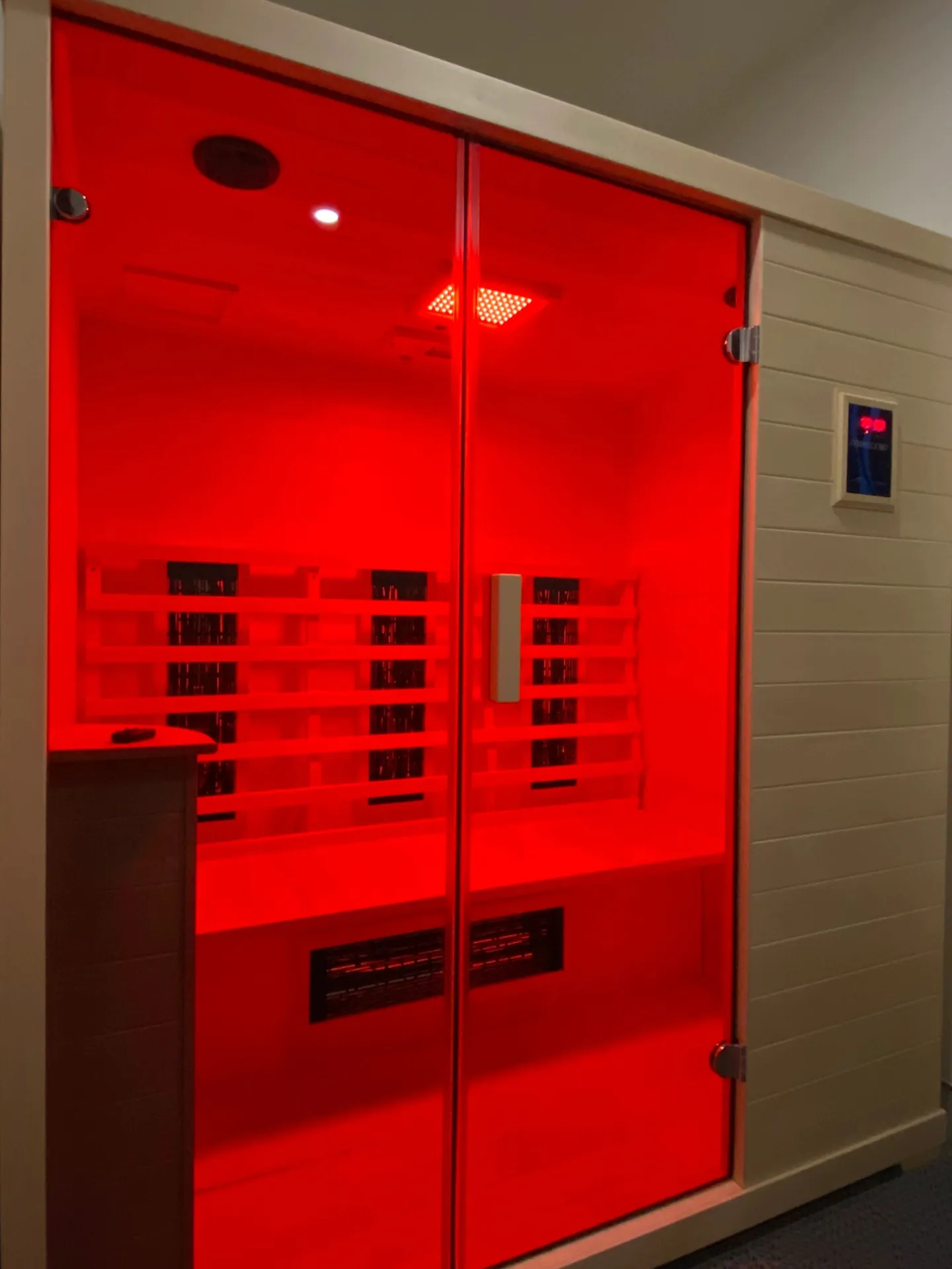 Red-lit infrared sauna at Durango Spine + Sport's private recovery suite